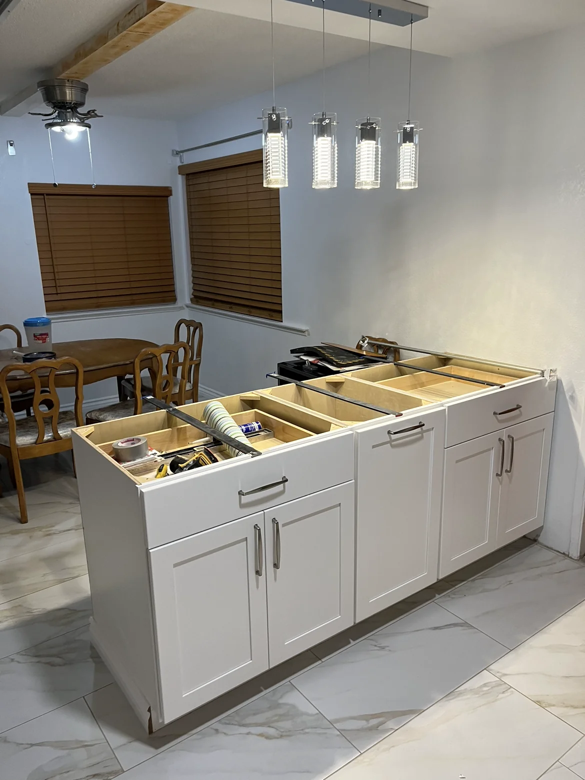 Peninsula cabinetry and pendant lighting during installation