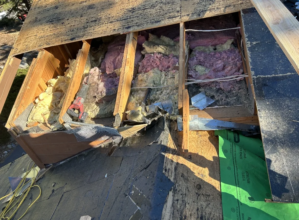 Exposed framing and insulation during roof work.